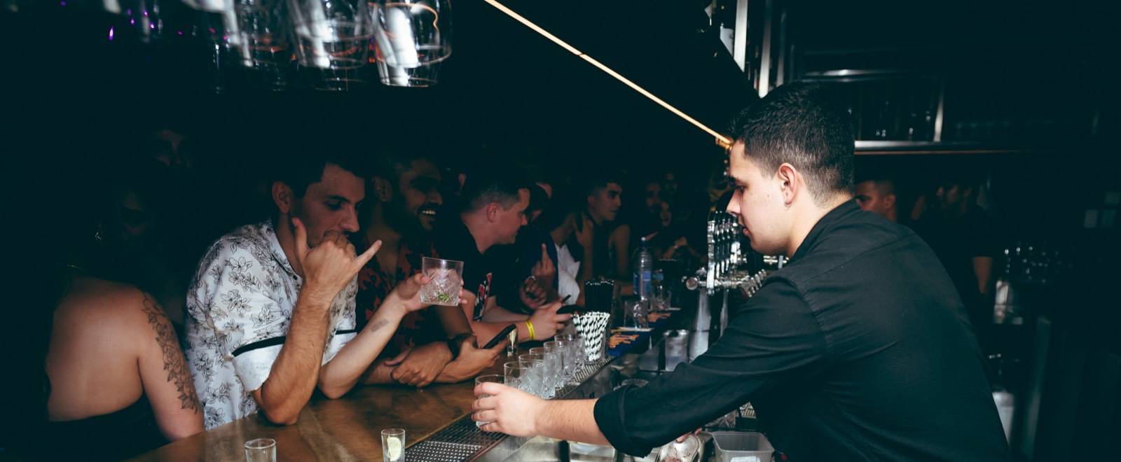 Bartender serving guests at Follies Bar